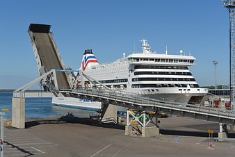 Large white ferry docked at port with raised ramp