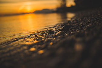 Golden Sunset Reflection on Rocky Shoreline