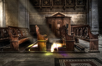 Sunbeams illuminating empty wooden pews in a historic church interior