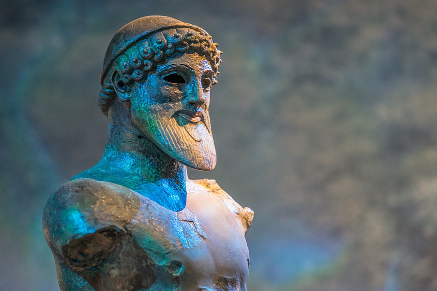 Close-up of ancient Greek bronze statue of Poseidon with blue patina