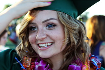 Happy Female Graduate Smiling in Green Cap and Gown