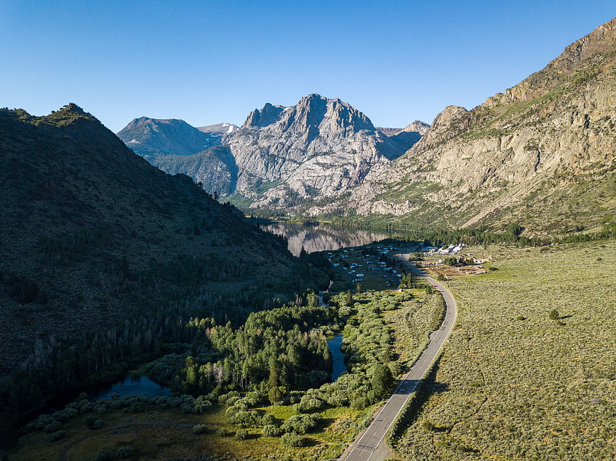 Aerial View of Winding Mountain Road and Alpine Lake