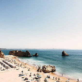 Aerial View of Busy Beach with Rock Formations and Blue Ocean