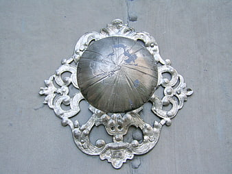 Vintage ornate silver door knocker on gray wooden door