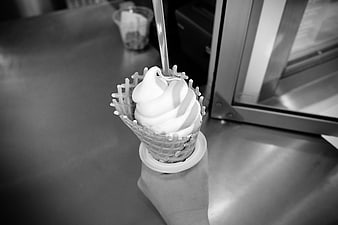 Black and white soft serve ice cream cone in hand