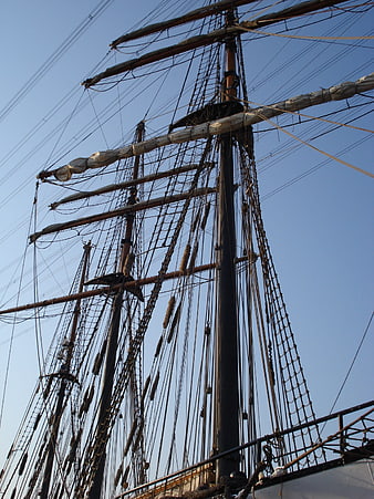 Tall ship masts and rigging against blue sky