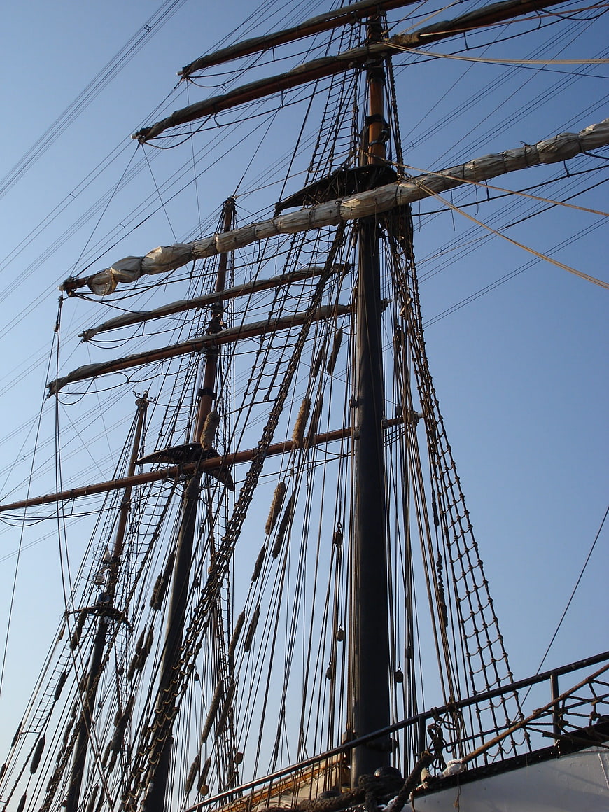 Tall ship masts and rigging against blue sky