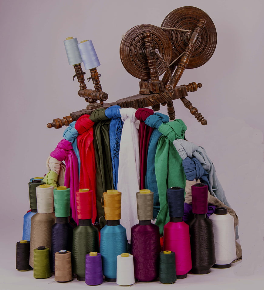 Colorful Spools of Thread and Wooden Spinning Wheel