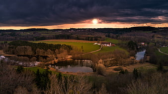 Dramatic Aerial View of Rural Landscape with Ponds and Farmhouse at Sunset