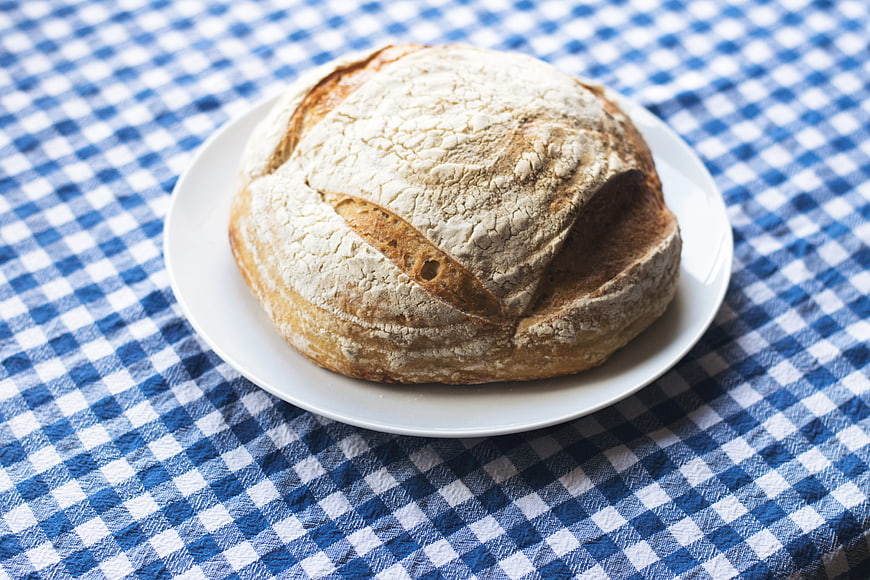 Rustic Sourdough Bread Loaf on Blue Checkered Tablecloth