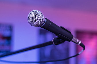 Close-up of Shure microphone on stand with purple stage lighting
