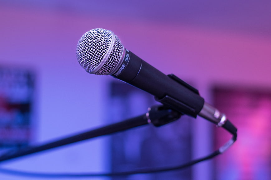 Close-up of Shure microphone on stand with purple stage lighting