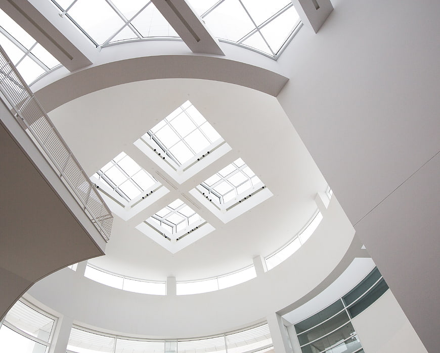 Modern white atrium ceiling with skylights and curved architecture