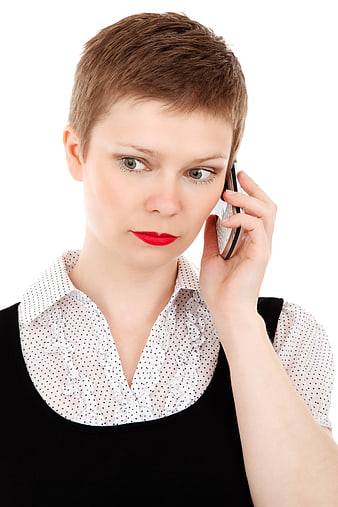 Serious woman with short hair talking on smartphone