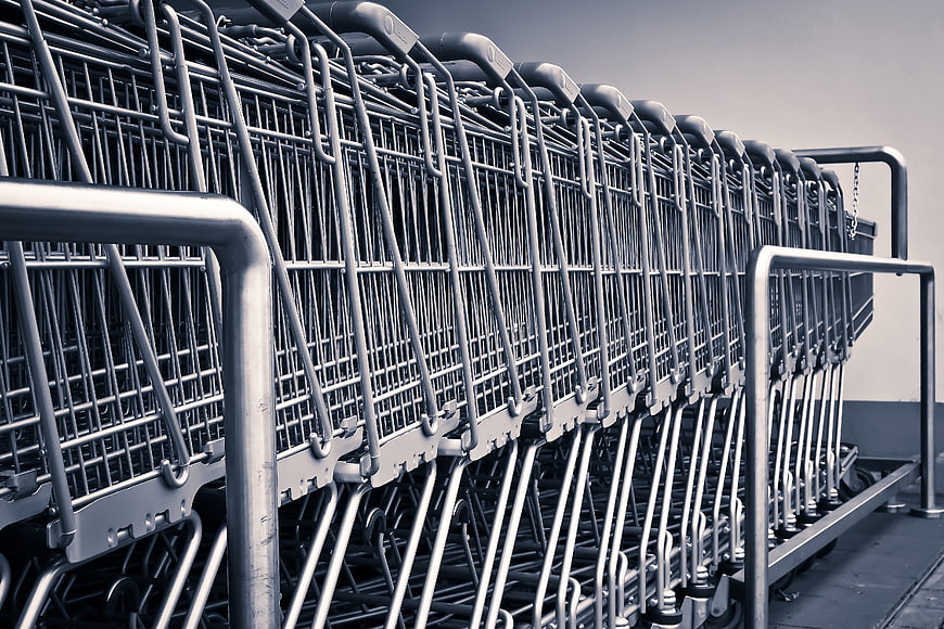 Row of nested metal shopping carts in a parking lot