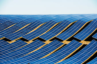 Vast Solar Panel Field Under Bright Blue Sky