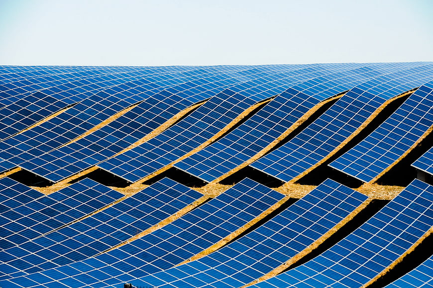 Vast Solar Panel Field Under Bright Blue Sky