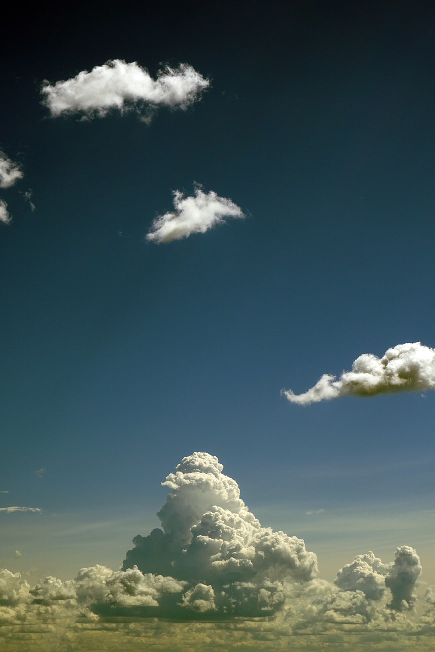 Dramatic cumulus clouds against deep blue sky