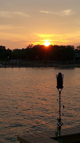 Golden Sunset Over Lake With Silhouetted Dock and Trees