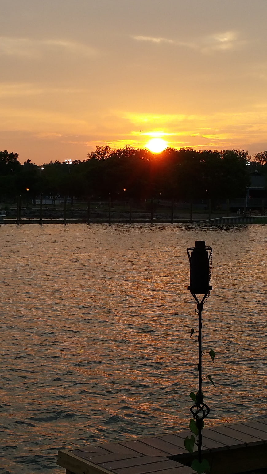 Golden Sunset Over Lake With Silhouetted Dock and Trees
