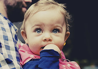 Close-up portrait of curious baby girl with blue eyes