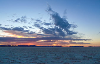 Sunset over Salar de Uyuni salt flats with dramatic clouds