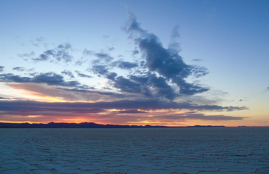 Sunset over Salar de Uyuni salt flats with dramatic clouds