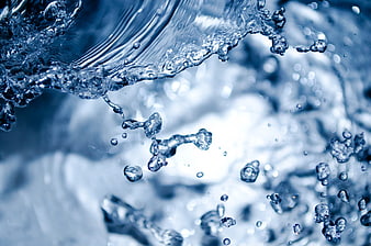 Close-up of splashing blue water droplets and ripples
