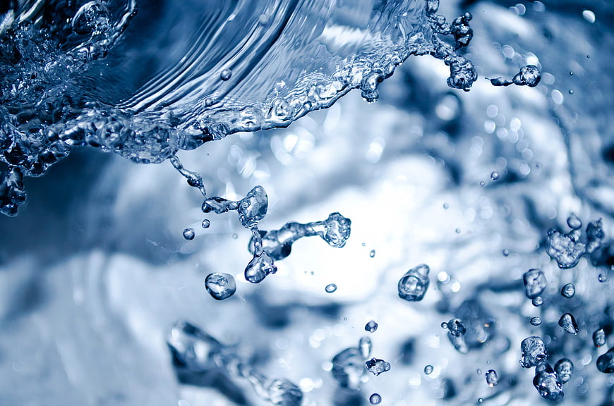 Close-up of splashing blue water droplets and ripples