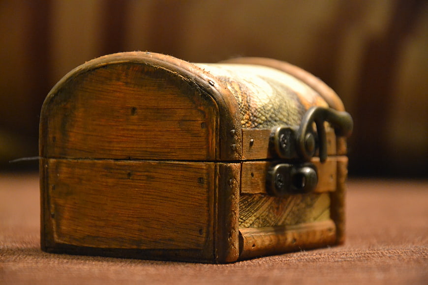 Vintage Wooden Treasure Chest With Metal Lock On Brown Fabric