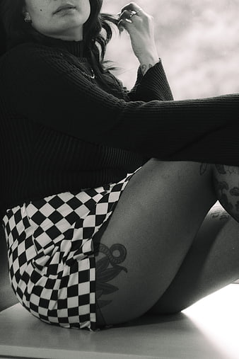 Black and white portrait of tattooed woman in checkered shorts