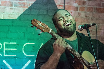 Passionate African American Male Musician Singing and Playing Guitar