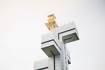 Modern geometric architecture with yellow lattice tower