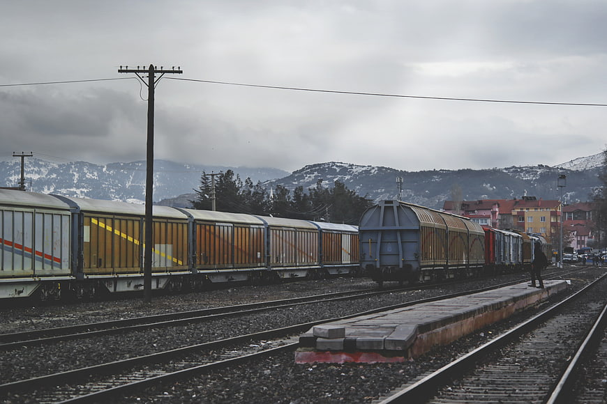 Freight trains on tracks with snowy mountains background