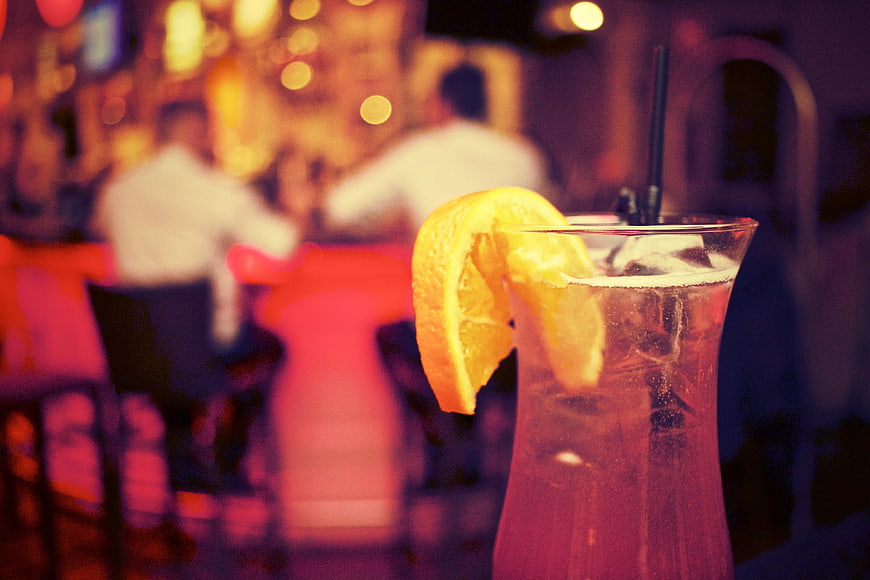 Refreshing cocktail with orange slice in a dimly lit bar