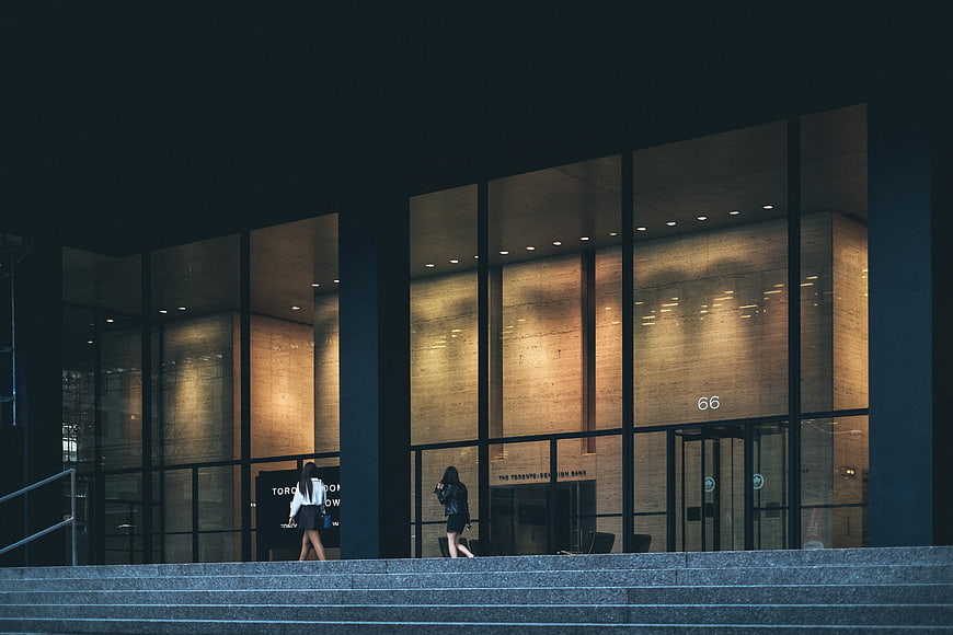 Modern Corporate Building Entrance at Dusk with People