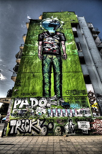 Urban street art mural of headless figure on green wall