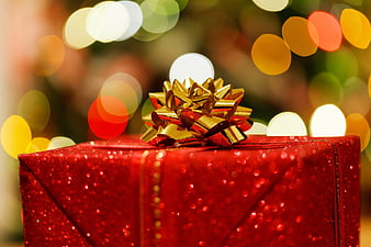 Red Glitter Christmas Gift Box with Gold Bow and Bokeh Lights