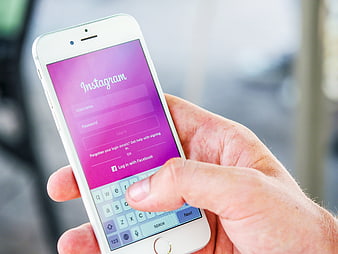 Hand holding smartphone with Instagram login screen