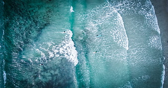 Aerial View of Surfers Riding Turquoise Ocean Waves
