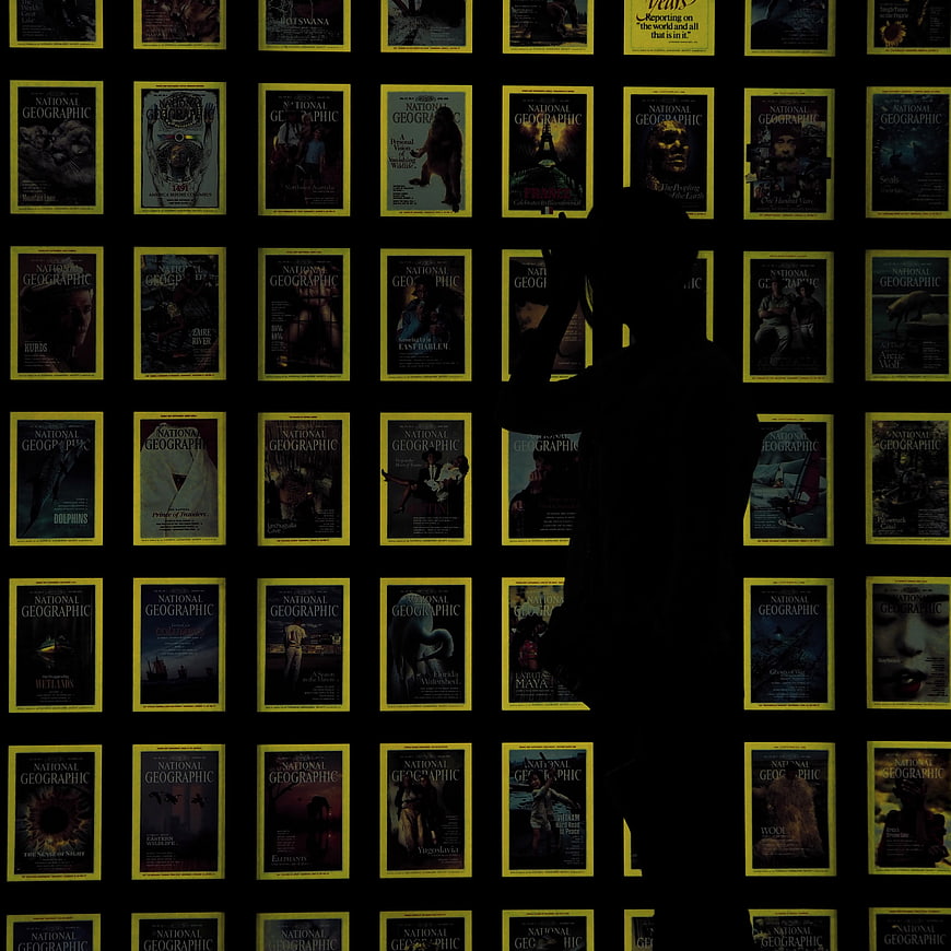 Silhouette of person standing in front of National Geographic magazine wall
