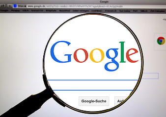 Magnifying glass over Google search engine logo on computer screen