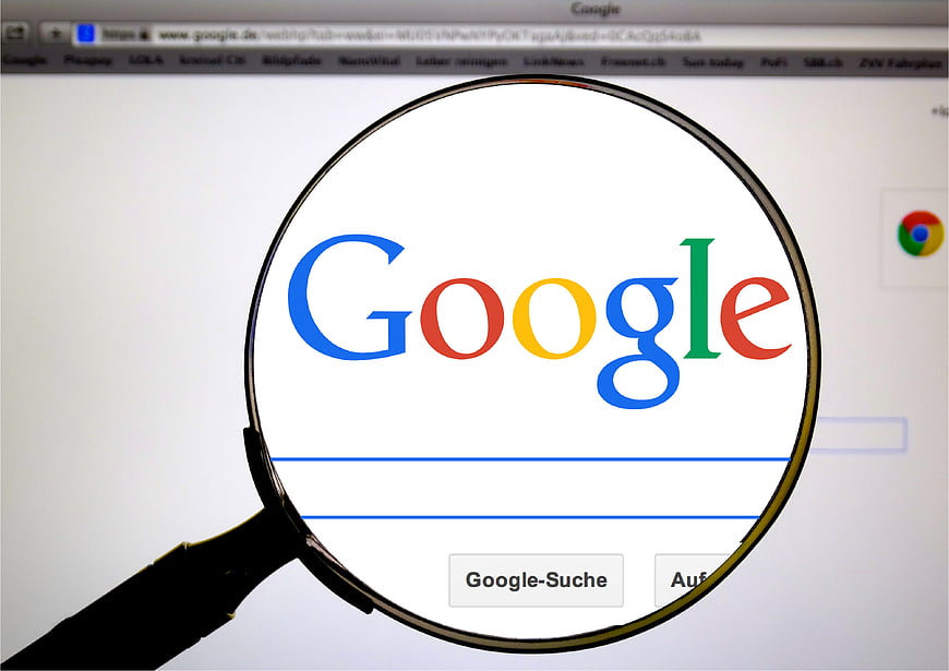 Magnifying glass over Google search engine logo on computer screen