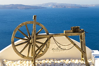 Vintage wooden water wheel overlooking Santorini caldera