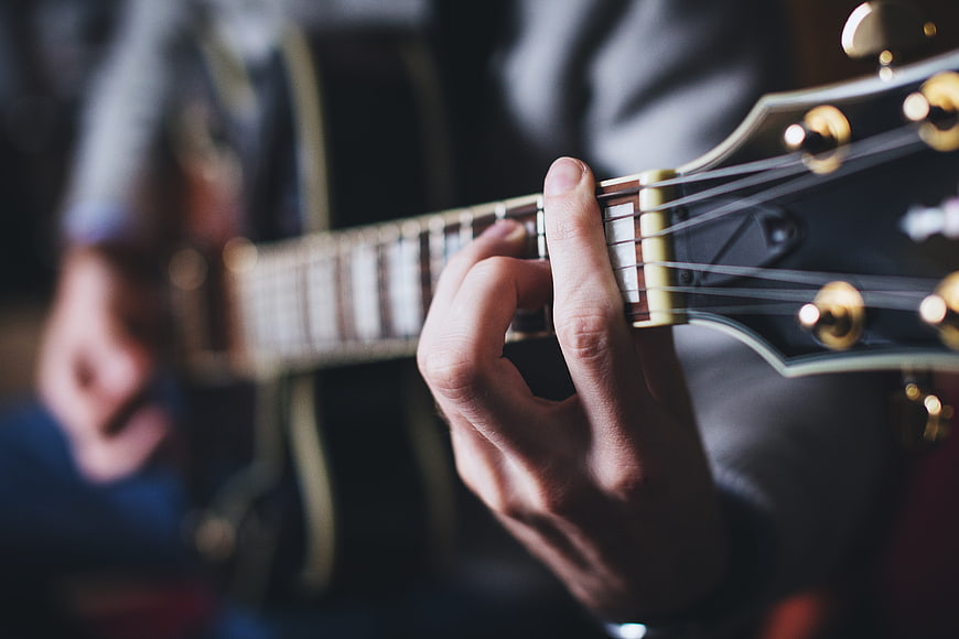 Close-up of hands playing acoustic guitar