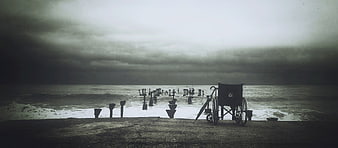 Lonely Wheelchair on Stormy Beach with Broken Pier