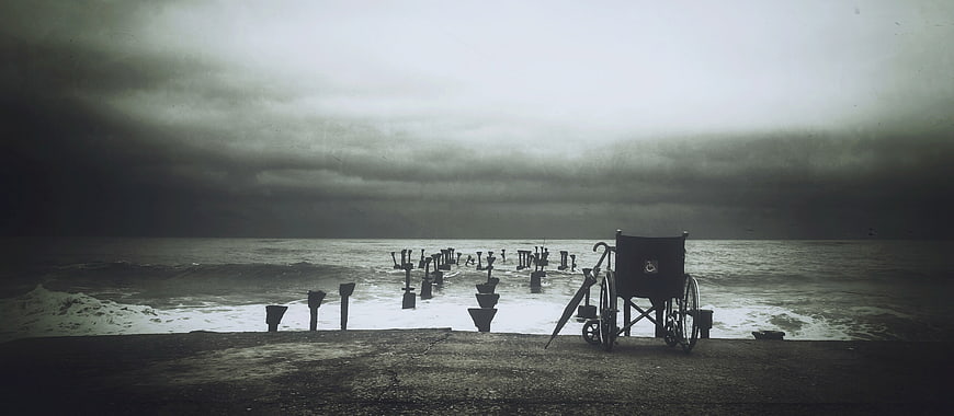 Lonely Wheelchair on Stormy Beach with Broken Pier