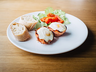 Healthy breakfast plate with eggs, ham, bread, and salad