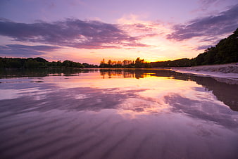 Vibrant Sunset Reflection on Calm Lake Water