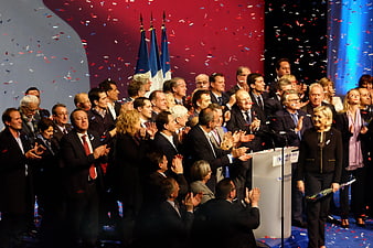 French political party gathering with confetti and flags